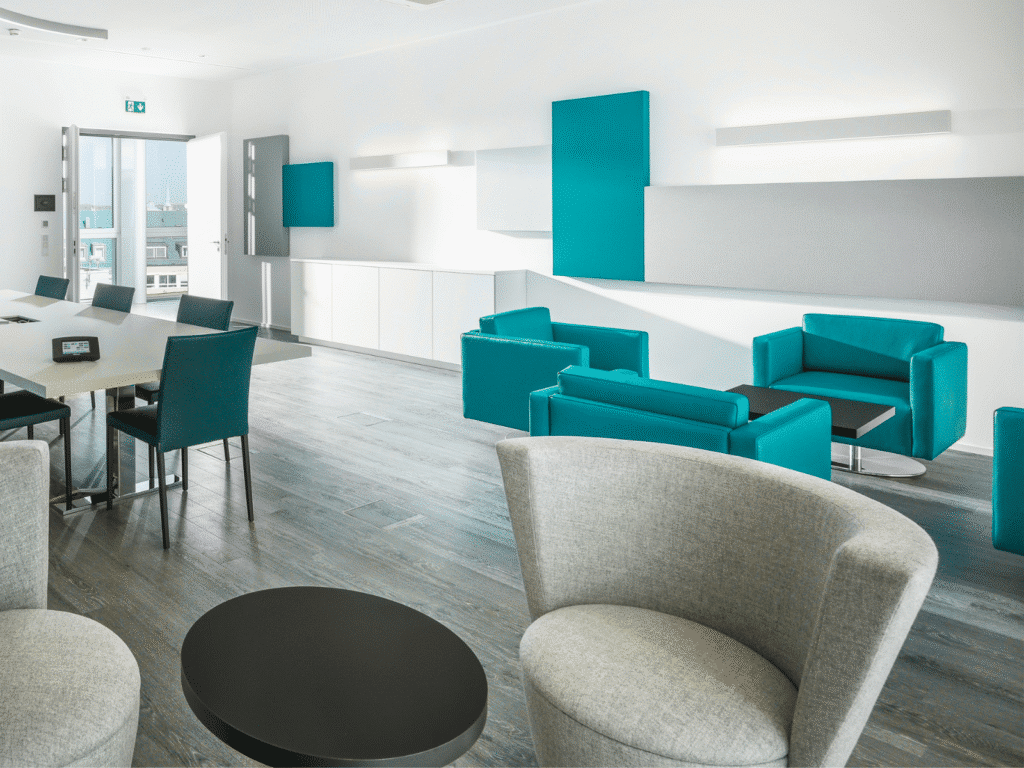 Meetingroom mit Sofa und Sesseln sowie einem Besprechungstisch mit einem Touchpanel bei der Universa Versicherung in Nürnberg